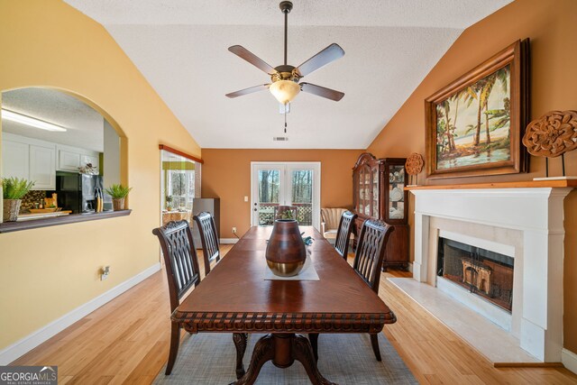 dining room featuring light wood-type flooring, vaulted ceiling, and ceiling fan