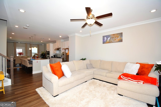 living room with dark wood-type flooring, ceiling fan, and ornamental molding