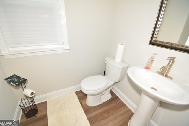 bathroom with hardwood / wood-style floors, toilet, and sink