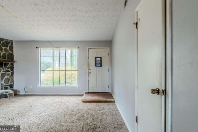 entrance foyer featuring carpet and a textured ceiling