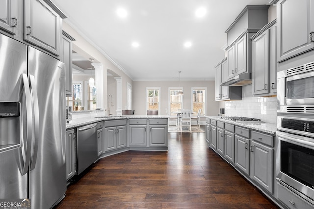 kitchen with gray cabinetry, hanging light fixtures, sink, appliances with stainless steel finishes, and light stone counters