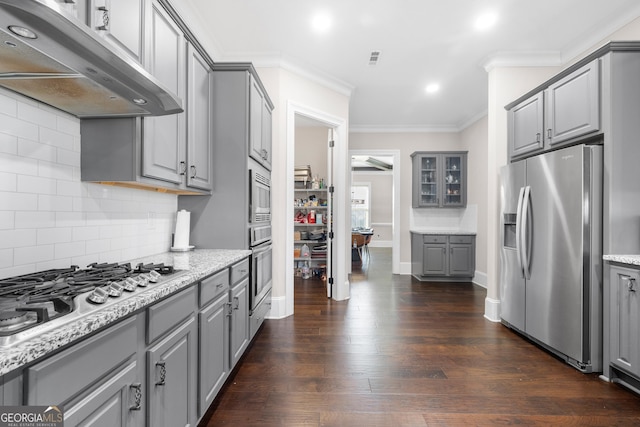 kitchen with light stone countertops, appliances with stainless steel finishes, tasteful backsplash, dark wood-type flooring, and gray cabinets