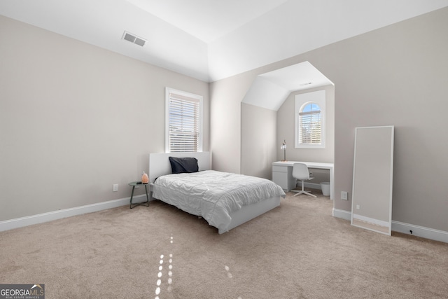 carpeted bedroom with multiple windows and vaulted ceiling