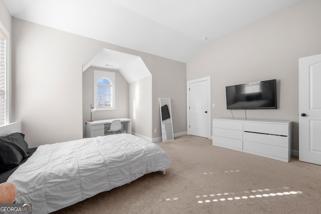 bedroom with light colored carpet and vaulted ceiling