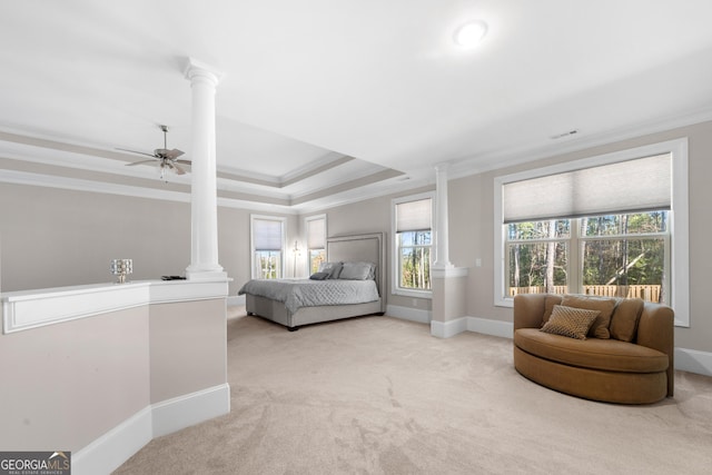 carpeted bedroom featuring a tray ceiling, ornate columns, ceiling fan, and ornamental molding