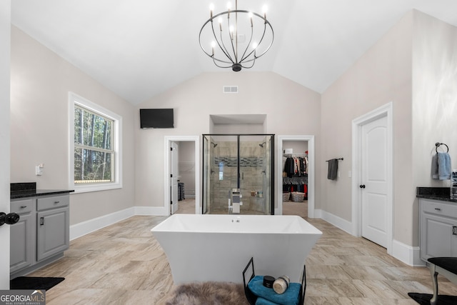 bathroom featuring plus walk in shower, vanity, lofted ceiling, and a notable chandelier