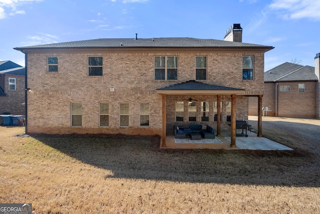 back of property with an outdoor living space, a patio, ceiling fan, and a yard