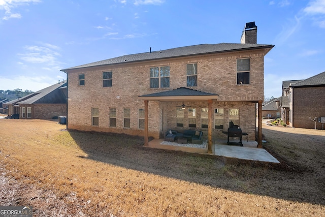 rear view of property featuring ceiling fan, a yard, a patio, and an outdoor living space