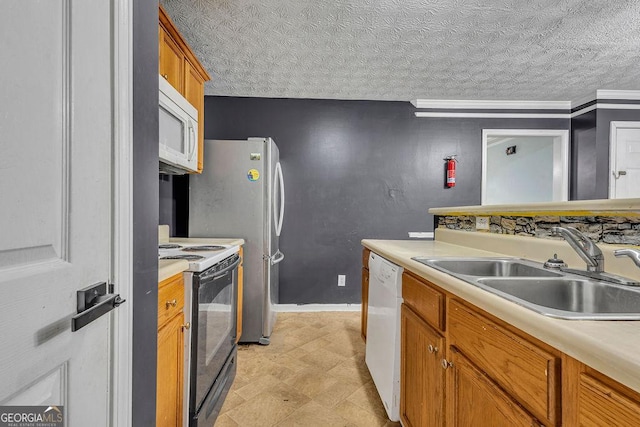 kitchen featuring white appliances, a sink, light countertops, and brown cabinets