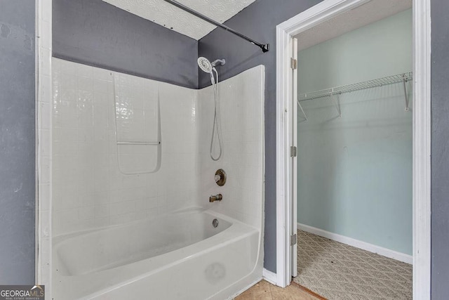 bathroom featuring shower / washtub combination, baseboards, and a walk in closet