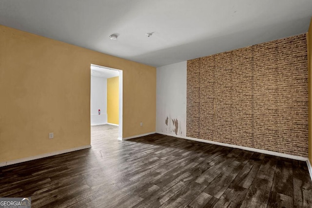 spare room featuring dark wood-style floors, baseboards, and a smoke detector