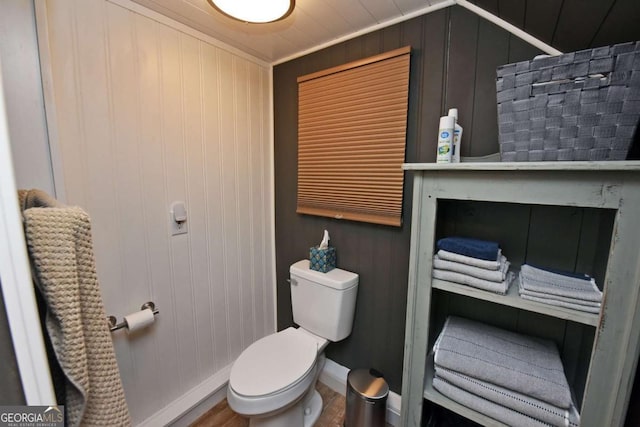 bathroom with hardwood / wood-style flooring, toilet, and ornamental molding