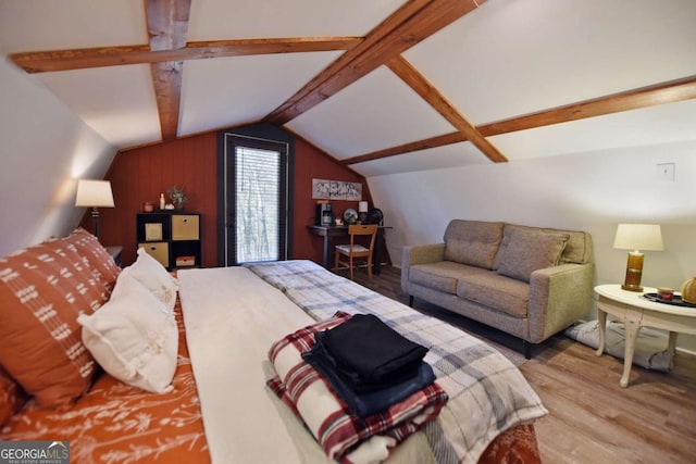 bedroom featuring wooden walls, wood-type flooring, and lofted ceiling