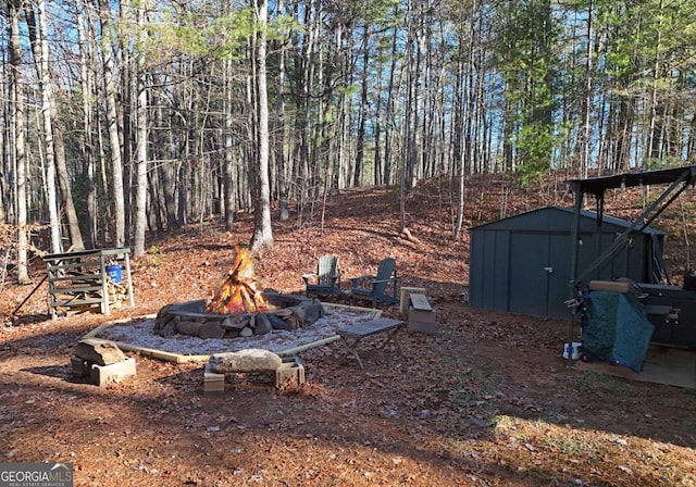 view of yard with a storage shed and an outdoor fire pit