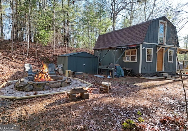 view of yard with cooling unit, a storage shed, and an outdoor fire pit