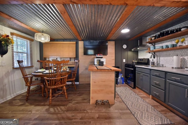 kitchen with electric range, sink, wall chimney range hood, dark hardwood / wood-style flooring, and pendant lighting