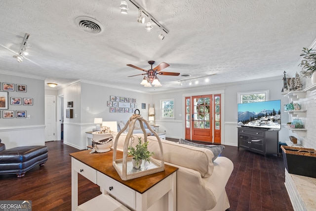 living room featuring rail lighting, ornamental molding, a textured ceiling, ceiling fan, and dark hardwood / wood-style floors