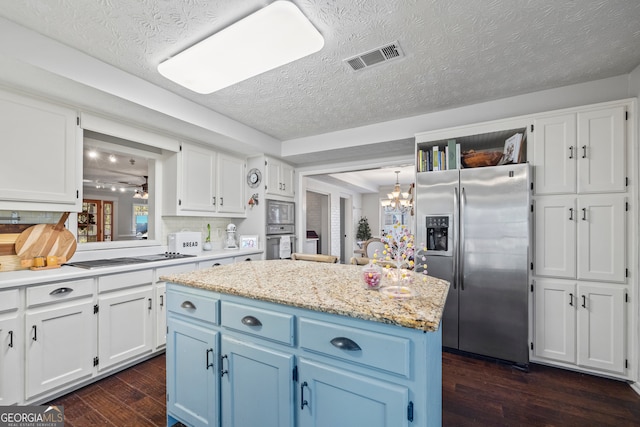 kitchen featuring a kitchen island, dark hardwood / wood-style floors, blue cabinets, white cabinets, and appliances with stainless steel finishes