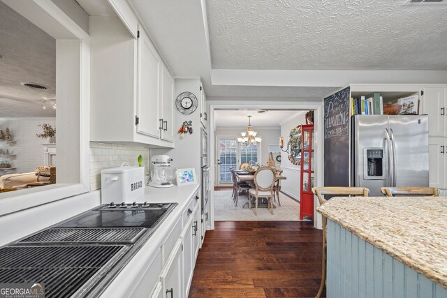 kitchen featuring backsplash, dark wood-type flooring, decorative light fixtures, white cabinets, and stainless steel fridge with ice dispenser