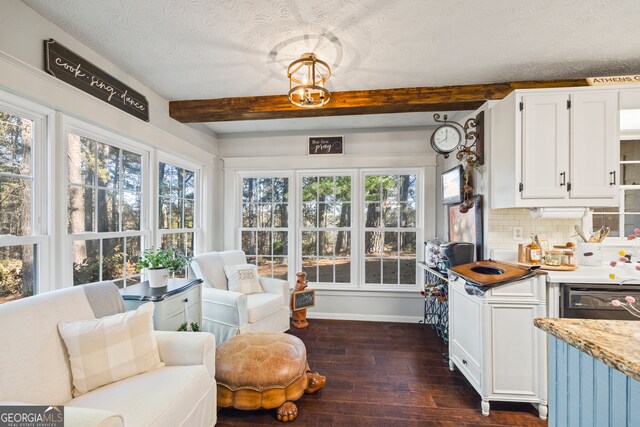 sunroom / solarium featuring beam ceiling and plenty of natural light