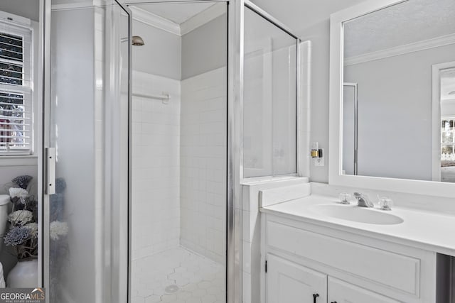 bathroom featuring vanity, a shower with shower door, and ornamental molding