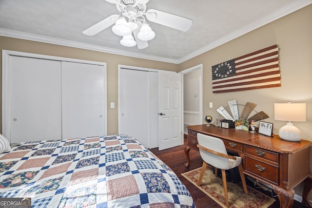 bedroom featuring ceiling fan, dark hardwood / wood-style flooring, a textured ceiling, two closets, and ornamental molding