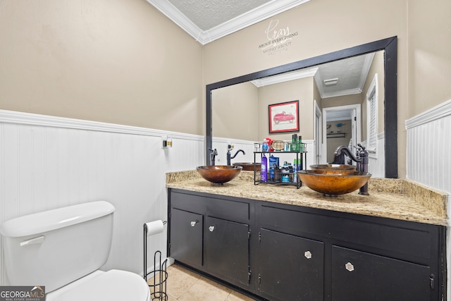 bathroom with tile patterned flooring, a textured ceiling, toilet, vanity, and ornamental molding