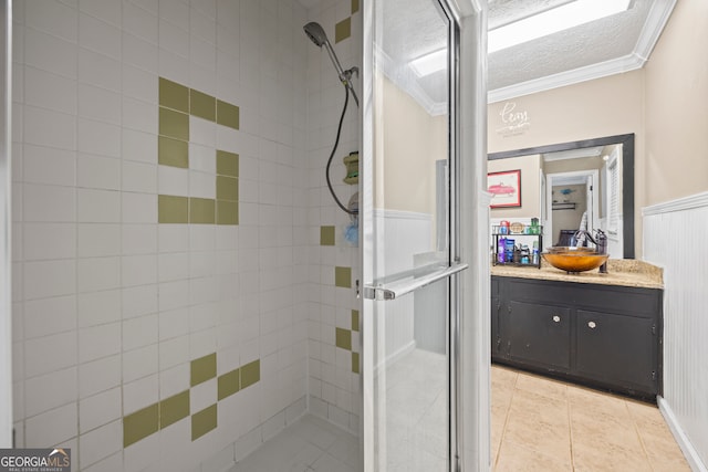 bathroom featuring tile patterned floors, an enclosed shower, ornamental molding, vanity, and a textured ceiling