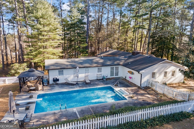 view of swimming pool featuring a gazebo, a diving board, and a patio area