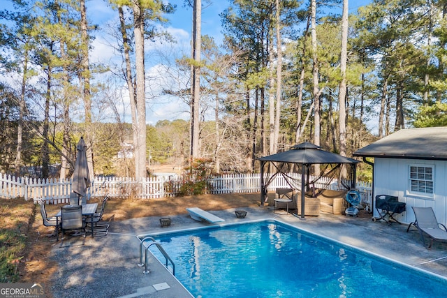 view of pool with a patio area, a diving board, and area for grilling