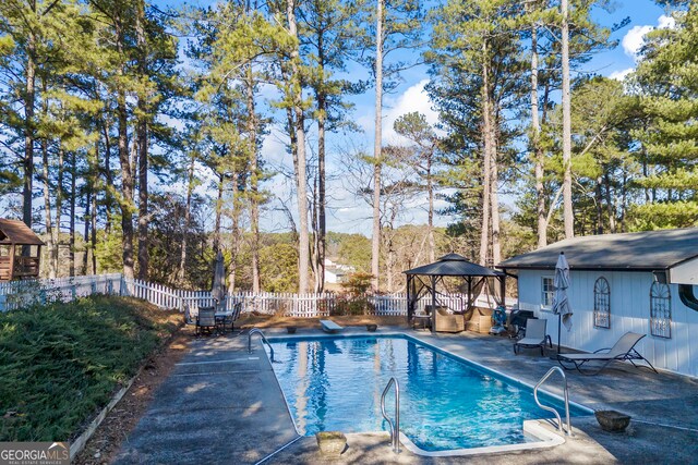 view of pool with a gazebo, a diving board, and a patio