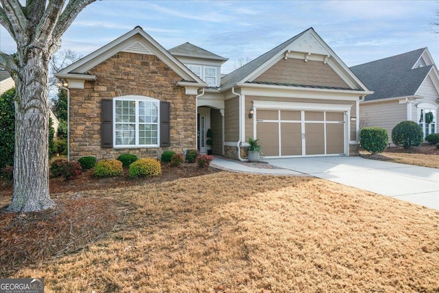 craftsman-style home featuring concrete driveway, stone siding, and an attached garage