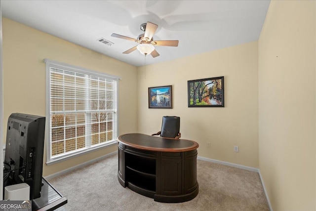 office area with plenty of natural light, ceiling fan, and light carpet