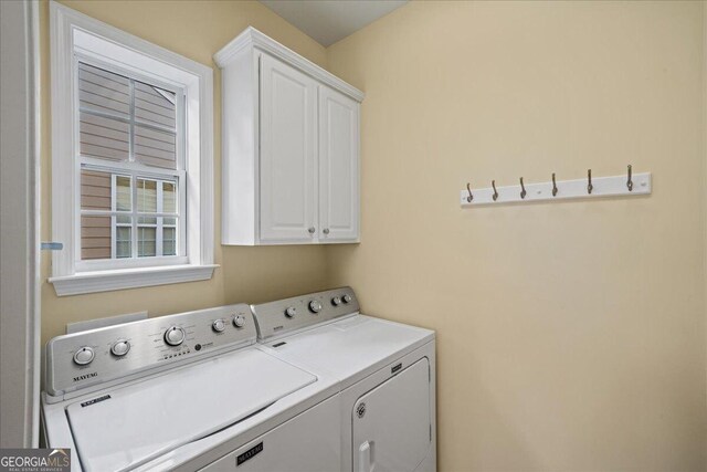 washroom with cabinets and washer and clothes dryer