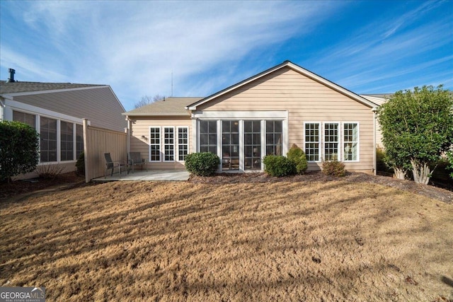 rear view of property featuring a patio and a lawn