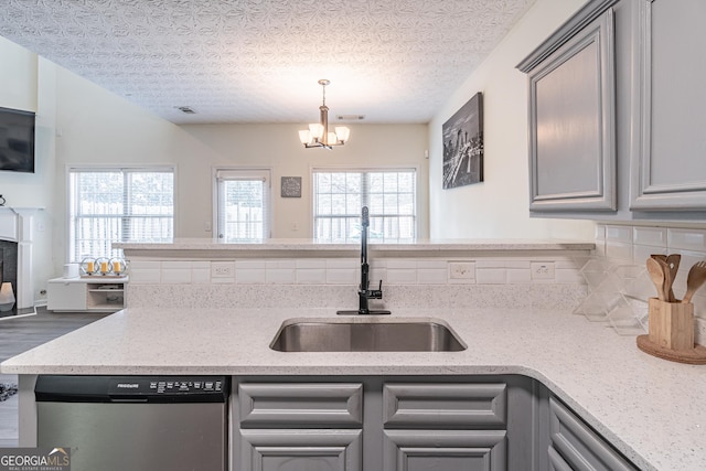 kitchen featuring a textured ceiling, sink, gray cabinets, dishwasher, and a chandelier