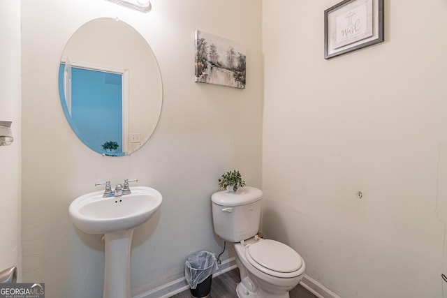 bathroom with toilet and wood-type flooring