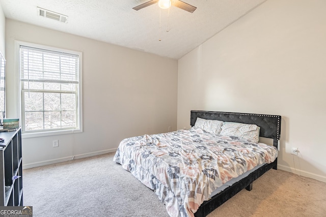 carpeted bedroom with ceiling fan and a textured ceiling