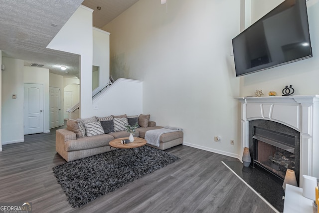 living room with dark hardwood / wood-style flooring and a towering ceiling