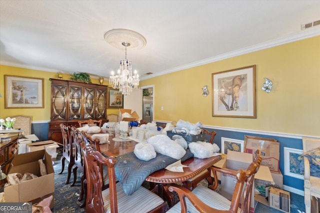 dining room featuring crown molding and a notable chandelier