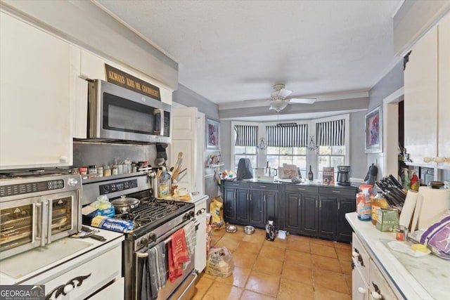 kitchen featuring white cabinets, ceiling fan, light tile patterned flooring, and appliances with stainless steel finishes