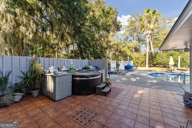 view of patio with a swimming pool with hot tub