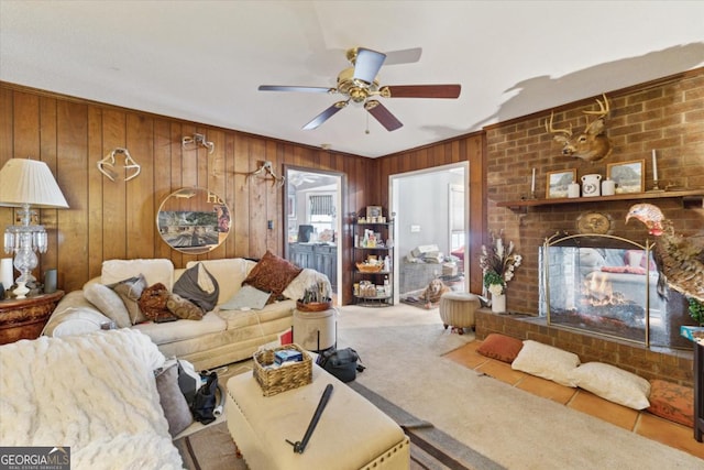 living room featuring ceiling fan, light carpet, wooden walls, and a brick fireplace