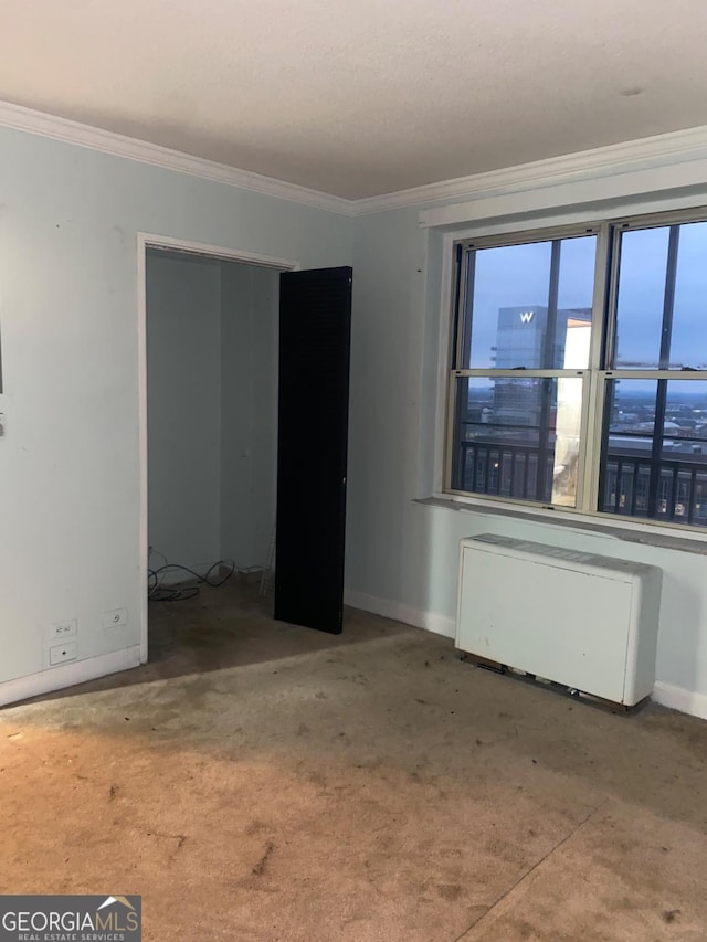 empty room with radiator heating unit and ornamental molding