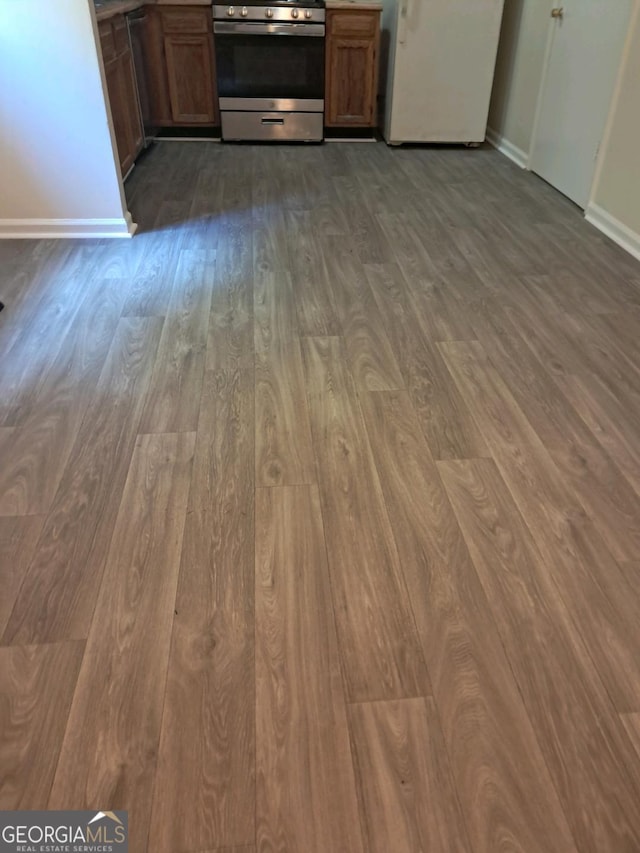 interior space featuring stainless steel range, white fridge, and light hardwood / wood-style flooring