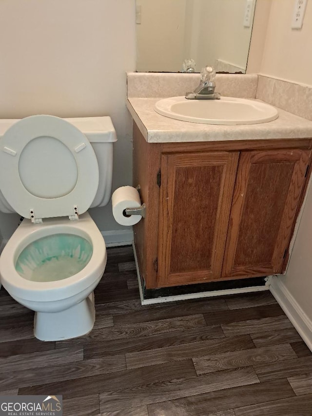 bathroom with vanity, wood-type flooring, and toilet