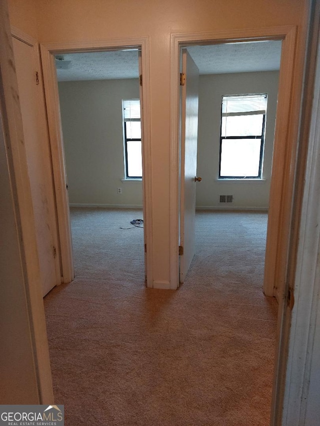 hallway with light colored carpet