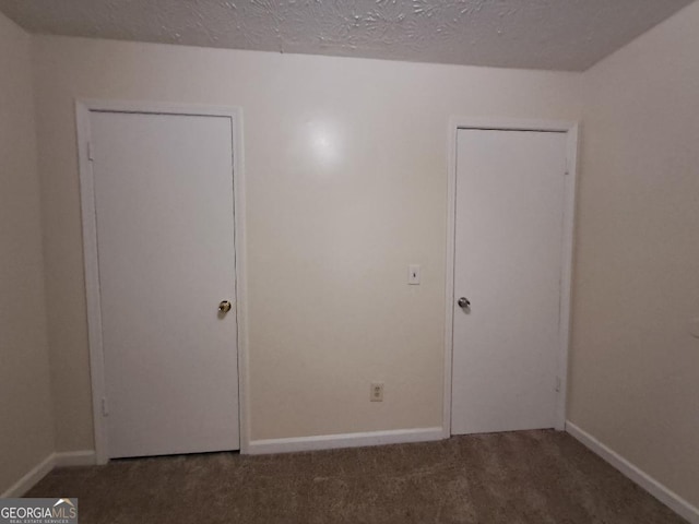 unfurnished bedroom with dark colored carpet