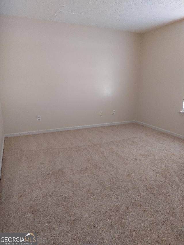 carpeted spare room with a textured ceiling