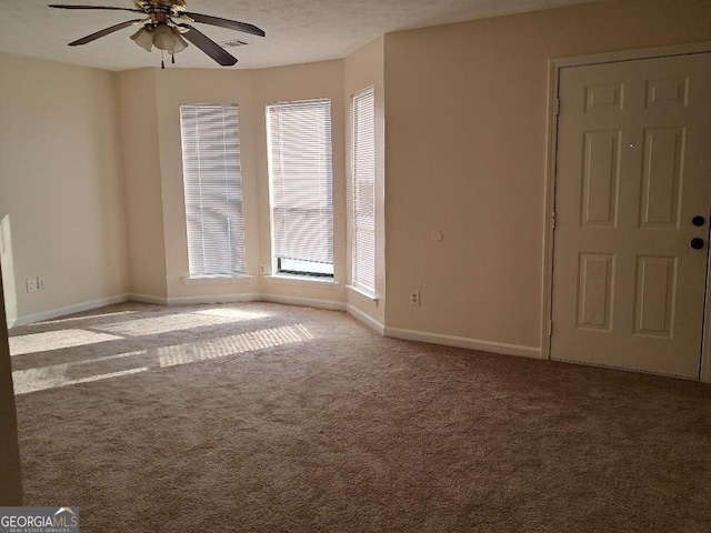 carpeted spare room with ceiling fan